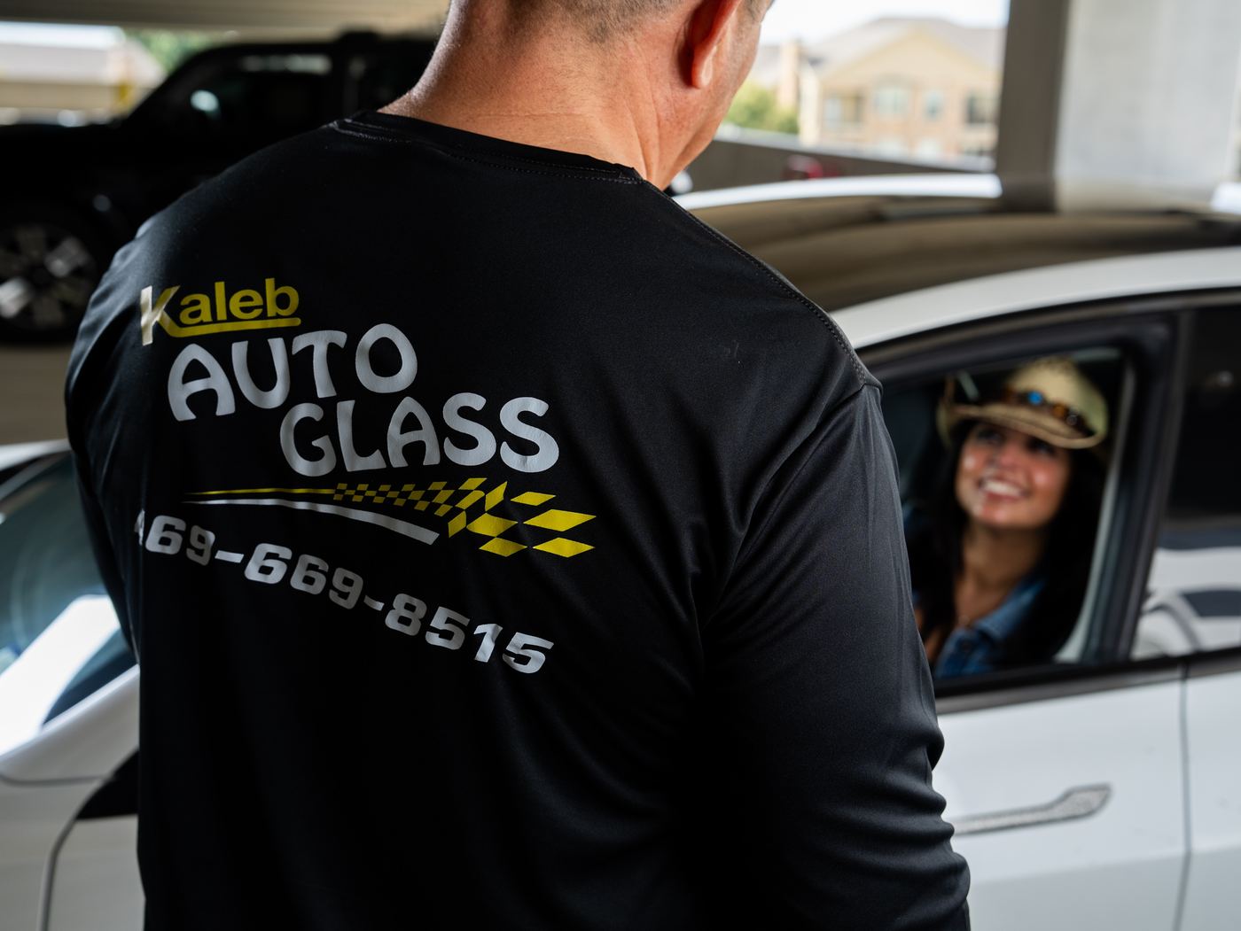 KAG technician talking with a smiling customer at her car