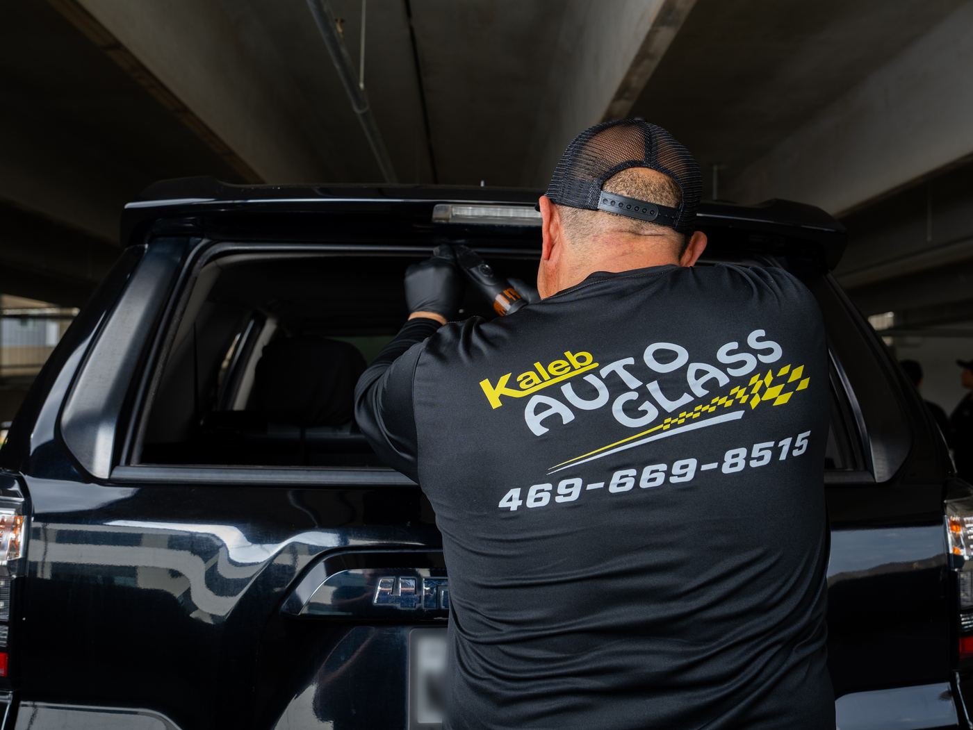 KAG technician installing back glass on an SUV